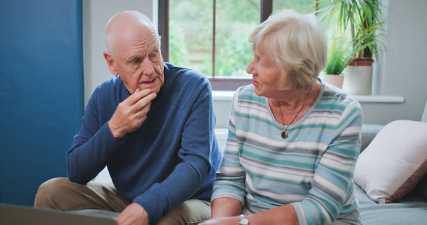 Senior couple, home and talking about mental health, stress or communication of anxiety, worry or discussion of retirement. Elderly, man and woman speaking about problem together in bedroom stock photo