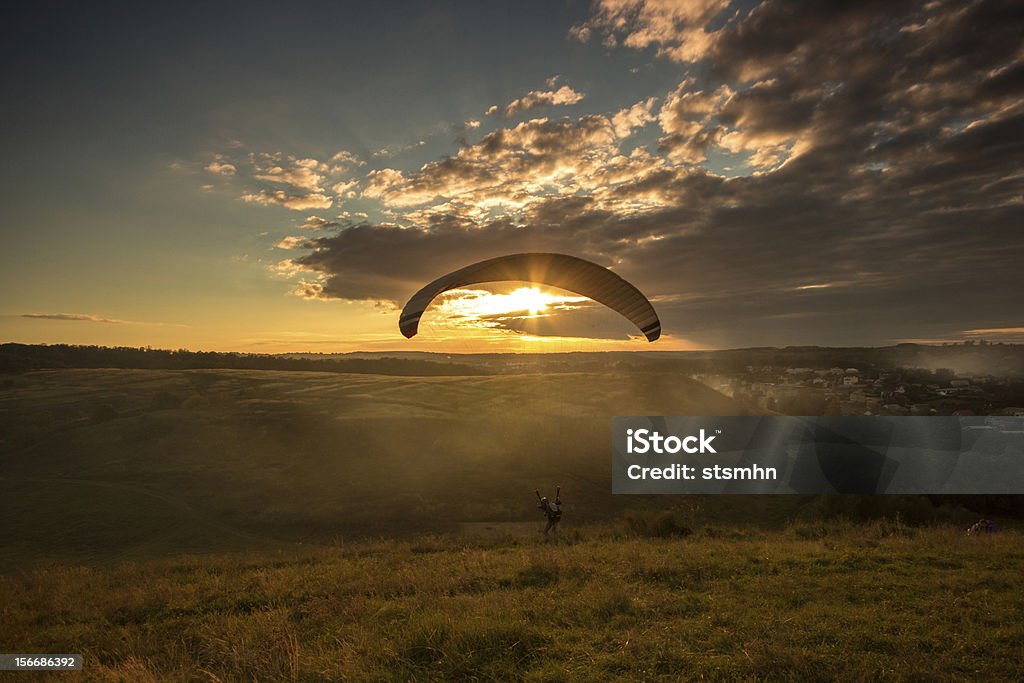 Paracadute salto oltre il tramonto - Foto stock royalty-free di Atterrare