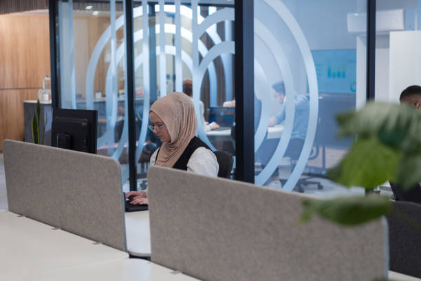 In a modern office setting, an African American businessman and his Muslim colleague, wearing a hijab, engage in collaborative discussions, tackling various business tasks and solving problems together, showcasing diversity, ambition, and teamwork in their dynamic and inclusive workplace en un entorno de oficina moderno, un hombre de negocios afroamericano y su colega musulmán, que llevan un hijab, participan en discusiones colaborativas, abordan diversas tareas comerciales y resuelven problemas juntos, mostrando diversidad, ambición y t