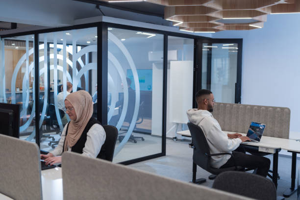 In a modern office setting, an African American businessman and his Muslim colleague, wearing a hijab, engage in collaborative discussions, tackling various business tasks and solving problems together, showcasing diversity, ambition, and teamwork in their dynamic and inclusive workplace en un entorno de oficina moderno, un hombre de negocios afroamericano y su colega musulmán, que llevan un hijab, participan en discusiones colaborativas, abordan diversas tareas comerciales y resuelven problemas juntos, mostrando diversidad, ambición y t