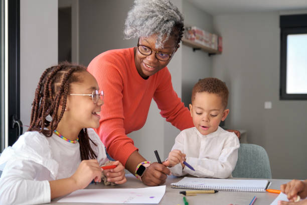 istock African mother helping her daughter with homework while her son is painting. 1566872954