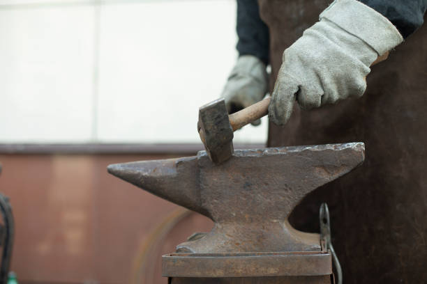 istock Blacksmith and Anvil. Hammer blow. Anvil on farm. 1566873501