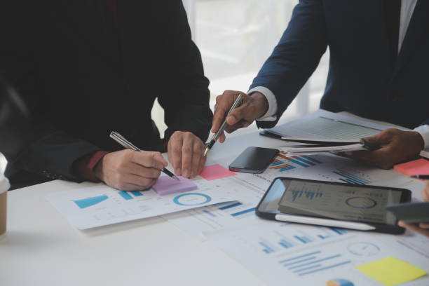 istock Financial analysts analyze business financial reports on a digital tablet planning investment project during a discussion at a meeting of corporate showing the results of their successful teamwork. 1566881105