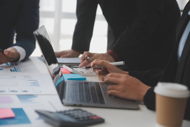 istock Financial analysts analyze business financial reports on a digital tablet planning investment project during a discussion at a meeting of corporate showing the results of their successful teamwork. 1566881107