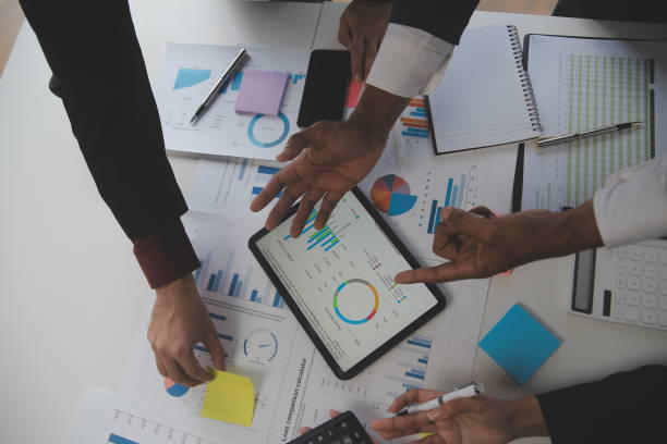 istock Financial analysts analyze business financial reports on a digital tablet planning investment project during a discussion at a meeting of corporate showing the results of their successful teamwork. 1566883841