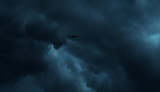 An airplane flying in stormy sky.
