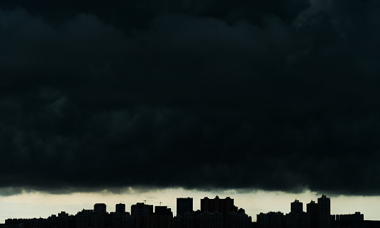 City under dark stormy clouds.