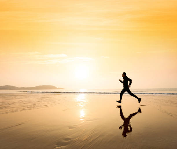istock Man running on the golden beach 1566907046