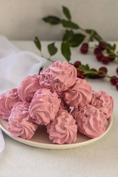 istock Cherry pink zephyr summer dessert on a light background 1566927047