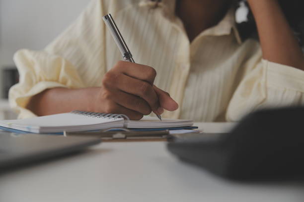 istock Asian Businesswoman Using laptop computer and working at office with calculator document on desk, doing planning analyzing the financial report, business plan investment, finance analysis concept. 1566933779
