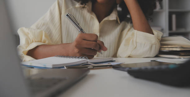 istock Asian Businesswoman Using laptop computer and working at office with calculator document on desk, doing planning analyzing the financial report, business plan investment, finance analysis concept. 1566933798