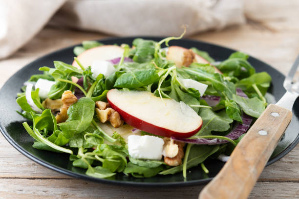 istock Autumn salad with apples and walnuts on wooden table 1566942213