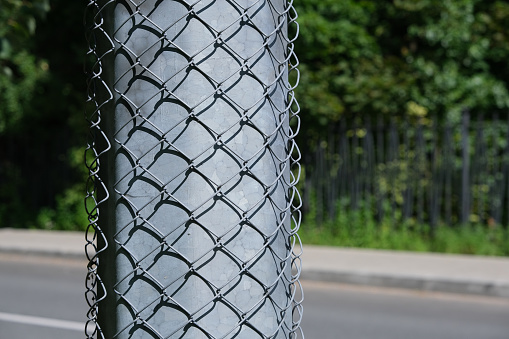 The concrete pole is covered with a metal mesh to prevent posting ads and stickers