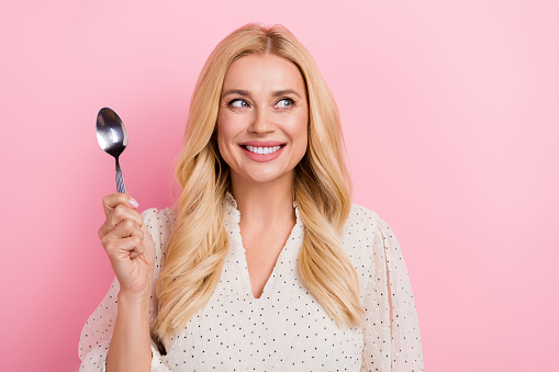 Photo of smile dreaming lady holding spoon utensil prepare eat her favorite ukrainian soup look cafe menu isolated on pink color background.