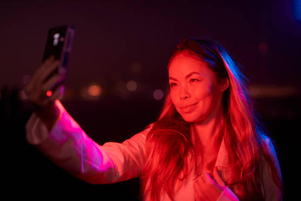 istock woman posing with red and blue lights at night 1566966632