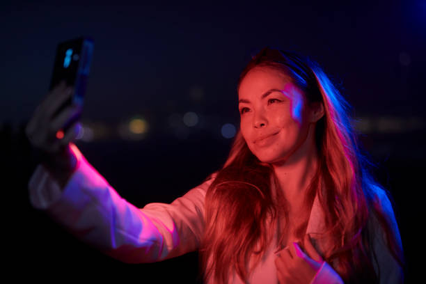 istock woman posing with red and blue lights at night 1566967723