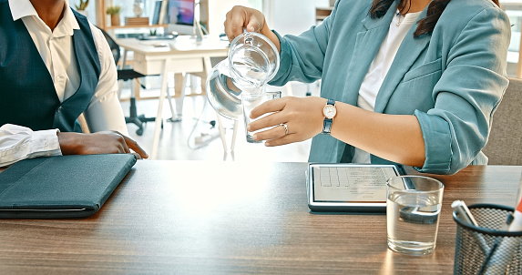 Pouring, water or hands of business people in meeting for consulting for a startup project together in office. Beverage in glass, tablet closeup or lawyer speaking of legal strategy to businesswoman
