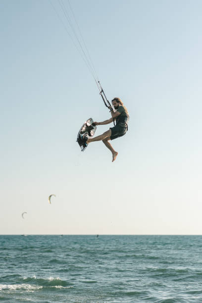 Kite surfer riding on a kite board above the sea