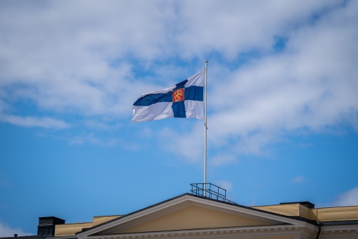 Finnish flag flying above Helsinki University in Finland on a sunny summer day