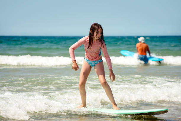 istock Pretty young girl sliding on ocean waves with her surfboard 1567009585