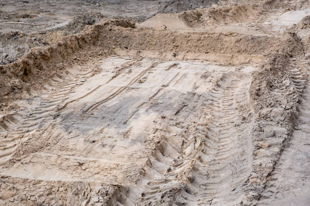 istock Sand and soil leveled by a tractor bucket at a construction site 1567018652