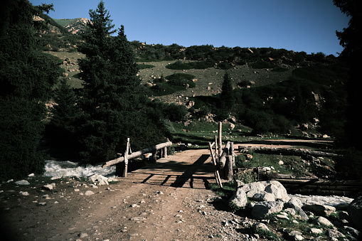 Rustical wooden bridge over mountain river. Juuku gorge, Issyk-Kul region