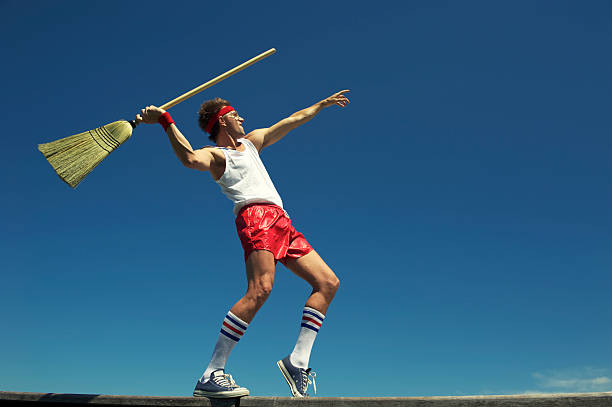 hipster nerd junger mann werfen besen speerwurf im freien blauen himmel - javelin stock-fotos und bilder