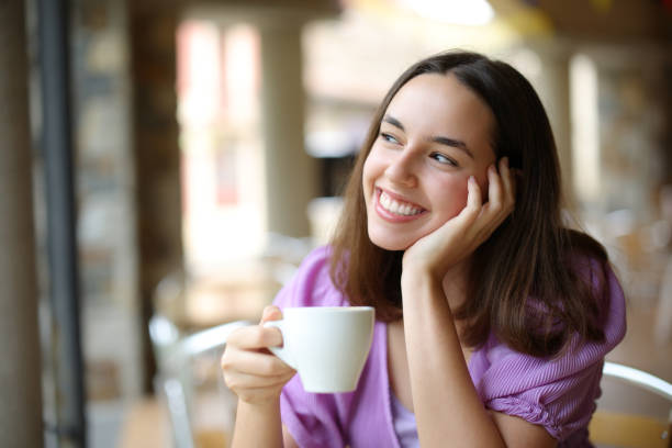 istock Dreamer woman drinking coffee and dreaming in a bar 1567075513