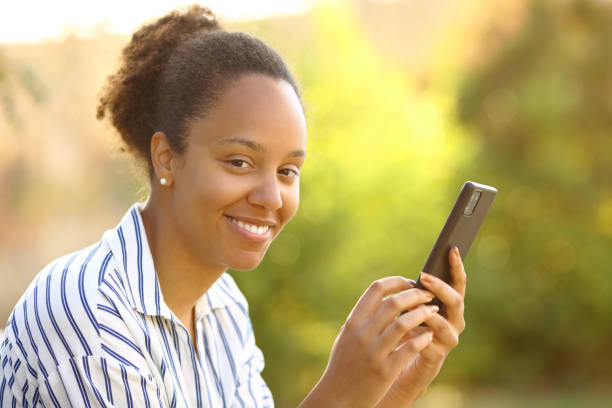 istock Happy black woman using smart phone looking at you 1567075541