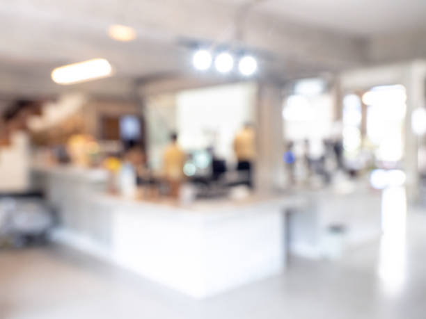 Abstract blurred modern white cafe workspace background with counter bar building interior office or indoor restaurant hall space. Blurry backgrounds for advertising and business presentation.
