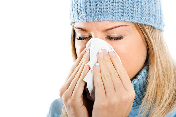 istock Young woman blowing into tissue 156709891
