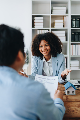 Real estate african american are delivering keys and houses to customers after agreeing to make a home purchase agreement and make a loan agreement or insurance.