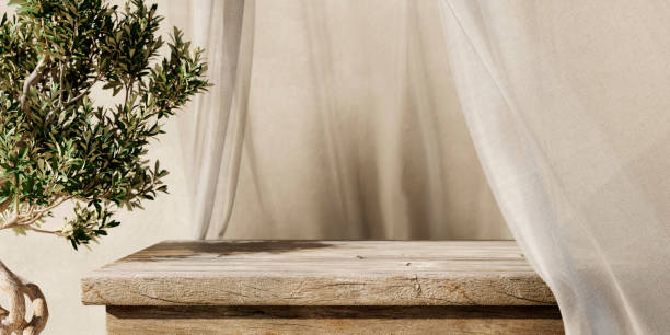 Natural wooden table and organic drapery with olive tree plant.