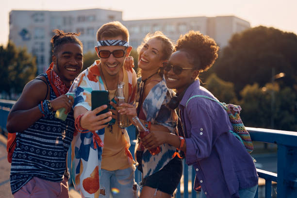 istock Young cheerful people taking selfie and having fun while going to open air music concert. 1567115741
