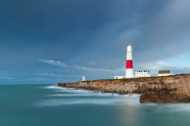 Portland Bill Lighthouse A long exposure of Portland Bill lighthouse as storm clouds pass overhead. bill of portland stock pictures, royalty-free photos & images