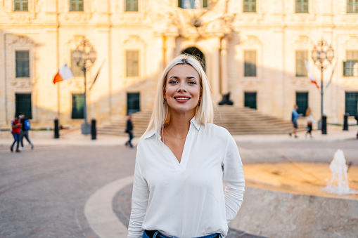 Portrait of a beautiful young blonde woman on the town square in Valletta, Malta.