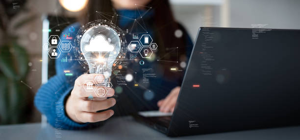 istock Woman holding light bulb with cloud icon. Digital technology concept, data sheet management with large database capacity and high security. Storage transition from computer to cloud computing. 1567144621