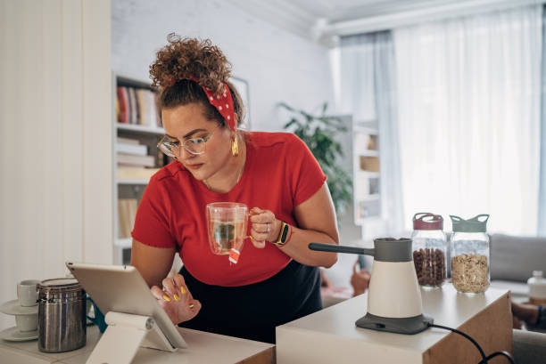 istock Smiling woman at home using digital tablet 1567145175