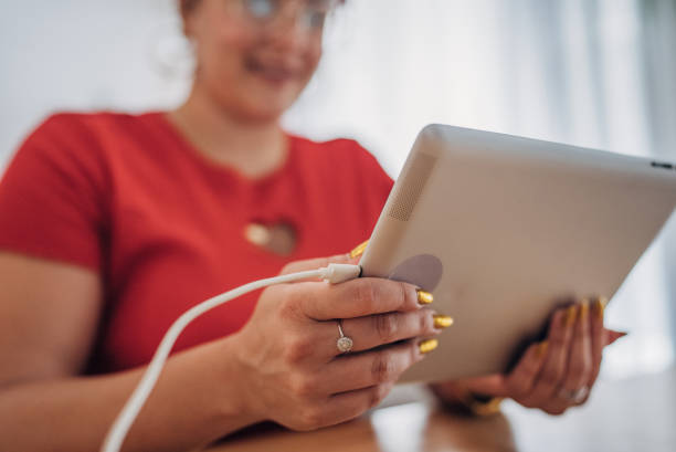 istock Smiling woman at home using digital tablet 1567149673
