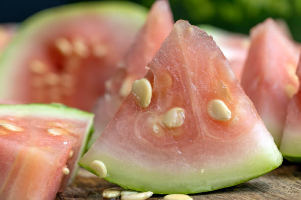 not sweet not ripe cut watermelon, Unripe watermelon of small size with large white seeds and light pink flesh