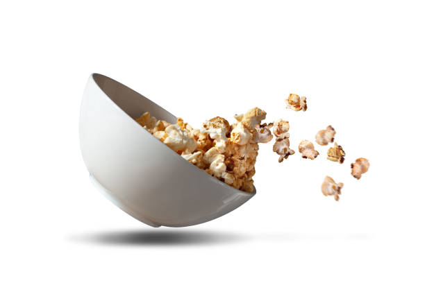 Popcorn falling out of a white bowl isolated stock photo
