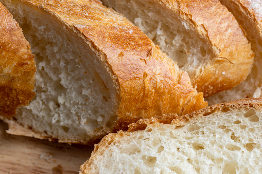 Sliced wheat bread into pieces, white traditional wheat bread with porous pulp