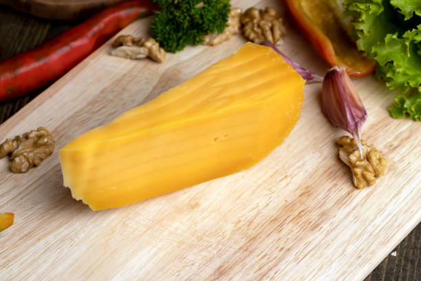 Sliced hard cheese made from milk, real aged yellow cheese on a board