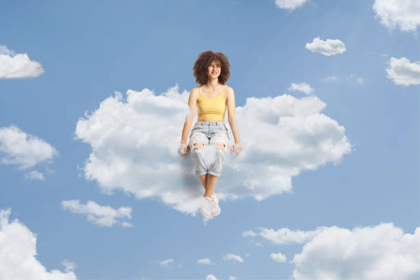 istock Young caucasian female with afro hairstyle sitting on a cloud 1567170064
