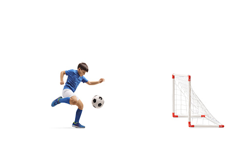 Full length shot of a boy scoring a goal isolated on white background