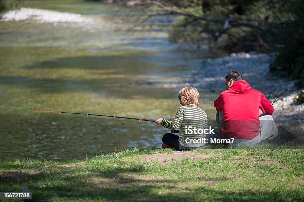 El Padre De Su Hijo La Enseñanza A Pescar En Río Foto de stock y más banco de imágenes de Familia - Familia, Niño, Pesca con mosca