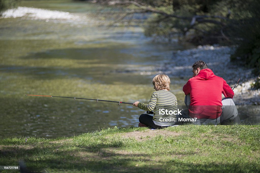 Pai ensinar o filho dele como peixe em um rio - Foto de stock de Criança royalty-free