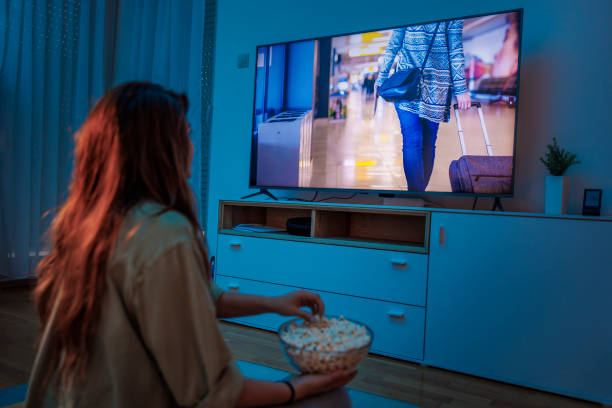 Woman watching a movie on TV at home stock photo