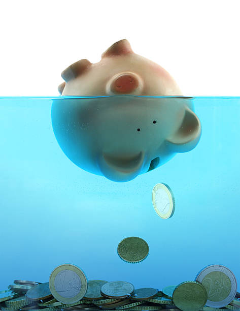 istock Piggy bank sinking in blue water 156722229