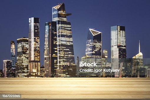 istock Empty wooden tabletop with beautiful New York skyscrapers at night on background, mock up 1567223365